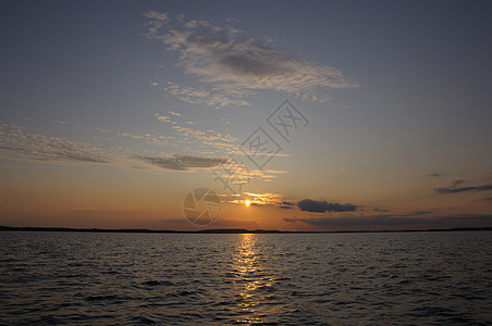 美丽的日落 在湖面的小云中阳光太阳地平线反射橙子天空金子天际场景蓝色图片