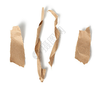 白面包上孤立的扭曲棕色纸条和撕破碎片图片