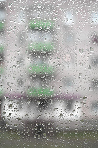窗户上的水滴时间灰色蓝色天气玻璃天空绿色雨滴下雨薄雾背景图片
