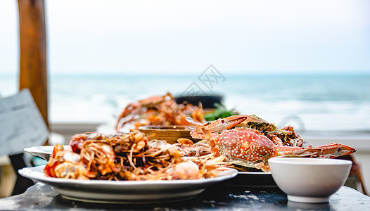 餐厅的海食蟹和背景中其他菜盘子香菜贝类美食动物桌子生物甲壳午餐橙子蓝色图片