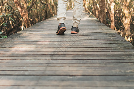 人类在通往自然的小型木桥上行走 用太阳耀斑漫步踪迹小路成人裙子蓝色牛仔裤男人日落团体女性图片