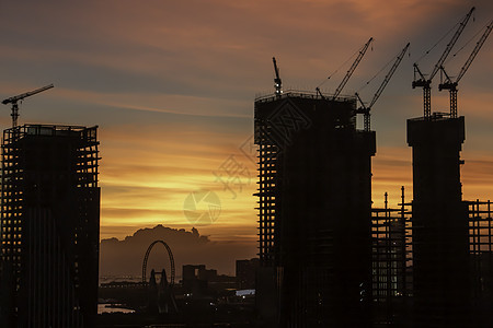 日落时建筑工地城市太阳工业工程橙子建筑学起重机天空商业工作背景图片