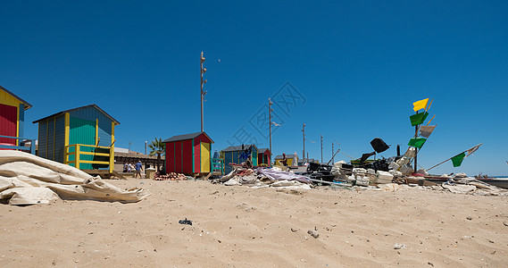 西班牙安达卢西亚Huelva渔村La Antilla捕鱼村典型的渔民小屋蓝色黄色鸟类渔具海滩展位海鸥绿色日光天空图片