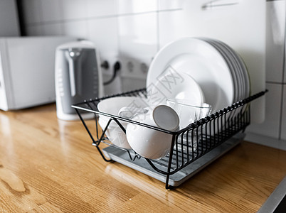 碗碟架可在木制台面 白色墙砖 水槽和水龙头上放置许多碗碟和杯子 现代斯堪的纳维亚厨房带排水板的经济型轻型抗菌洗碗机托盘用具排水器背景图片