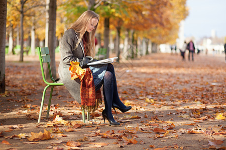 女孩在公园看书金发女郎季节女士城市晴天金发阳光长发外套椅子图片