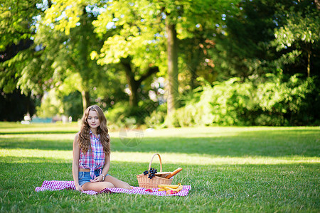 女孩在公园野餐篮子闲暇牛仔裤小吃假期食物头发短裤青少年幸福图片