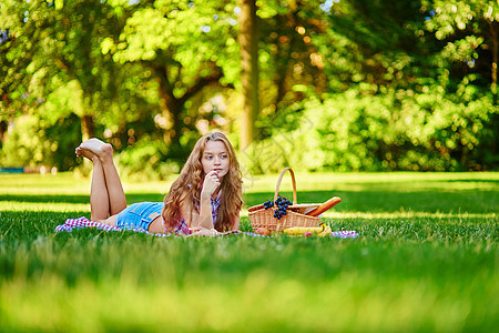 美丽的女孩在公园野餐金发篮子牛仔裤头发赤脚食物女士青少年成人幸福图片