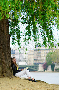 巴黎一棵树下的女孩阅读图片