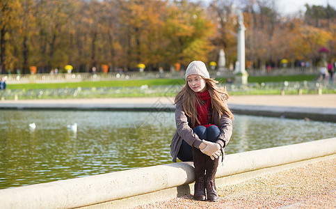 女孩在巴黎享受阳光明媚的春天白色池塘帽子公园女士城市花园背景图片