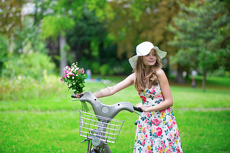 带自行车和鲜花的快乐少女女性农村潮人裙子女孩旅行野餐城市公园花束图片