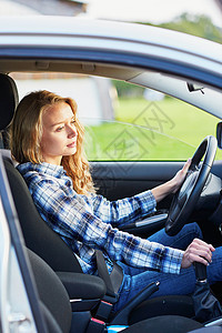 驾驶汽车的年轻妇女测试金发旅行腰带交通玻璃运输学习挡风玻璃晴天图片