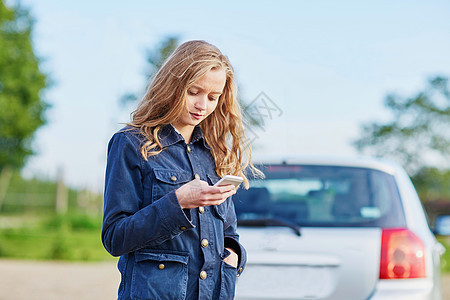 妇女在路上靠近一辆破车行驶 要求帮助生活女士女孩树干城市旅行电话车辆司机商业图片