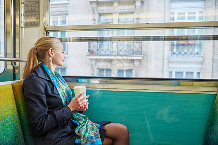乘坐巴黎地下火车和喝咖啡的女乘地铁的妇女;图片