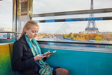 美丽的年轻女子乘坐巴黎地下的火车 阅读一本书 女主角工具旅行旅游交通窗户民众工作游客乘客女士图片