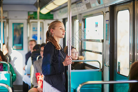 年轻妇女乘坐巴黎地下地铁列车旅行的女青年工作城市乘客运输交通火车民众女士窗户白色图片