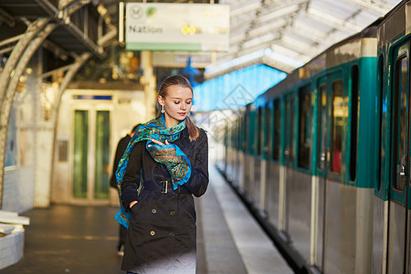 等待巴黎地下地铁平台火车的年轻女子 为她们服务女士乘客铁轨工作女孩运输旅行民众白色城市图片