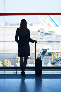 在国际机场旅行的年轻女性青年女旅客航空蓝色行李天空航班反射假期运输通勤者建筑图片