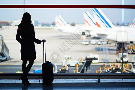 在国际机场旅行的年轻女性青年女旅客运输反射蓝色行李建筑套装天空女孩班级休息室图片