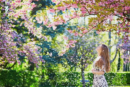 在盛开的春天公园 美丽的年轻女子过敏花园金发阳光花粉成人女士农村公园花瓣图片