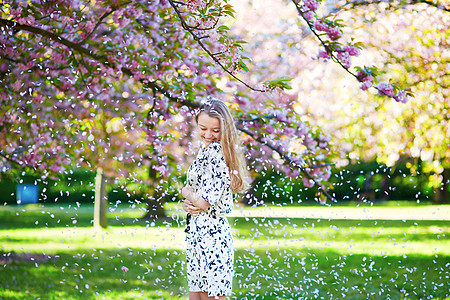 在盛开的春天公园 美丽的年轻女子白色女孩樱花金发季节性过敏公园花瓣阳光农村图片