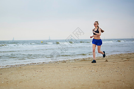 年轻健身女跑步在海滩上慢跑海滨速度活动蓝色运动女士臀部海洋有氧运动胸罩图片