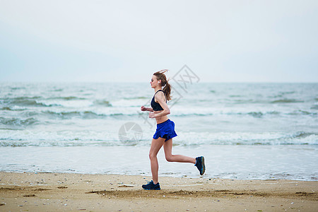 年轻健身女跑步在海滩上慢跑有氧运动训练肌肉锻炼海岸女孩海洋腰部运动装成人图片