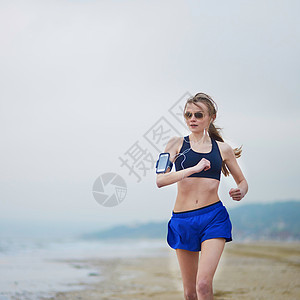 年轻健身女跑步在海滩上慢跑腰部力量女孩锻炼慢跑者海洋臀部海岸线运动速度图片