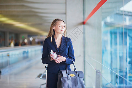 在国际机场持有护照和登机证的商家妇女 女商务人士图片