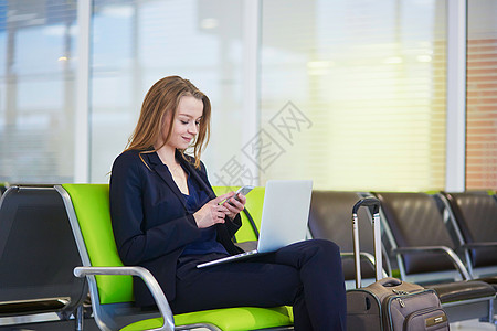 女驾驶员素材在国际机场候机站检查她的电话的女驾驶员背景
