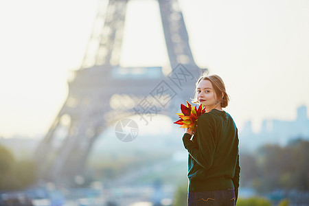 枫叶巴黎埃菲尔塔附近的美丽的法国年轻女子 在金发女性旅游目的地理发城市成人阳光旅行树叶背景