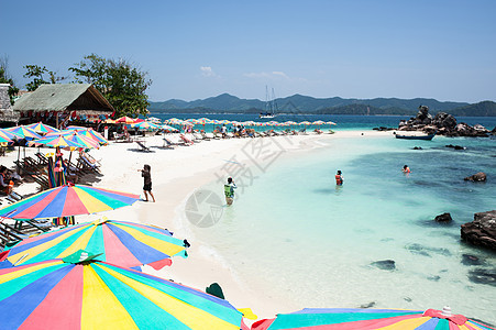 泰国普吉海滩的旅游者放松蓝色天空躺椅晴天赤道海浪海洋稻草休息室享受图片