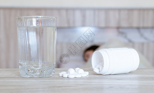 被冷冻感染的Flue药女放在桌子上和一杯水上喷嚏治疗医疗部位沙发医学药片鼻子青春期流感图片