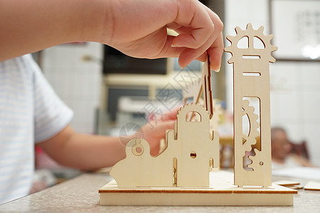 一个孩子在玩 3d 木制拼图 零件包括齿轮导轨游戏商业小路玩具安全学习风险建筑学木头地面图片