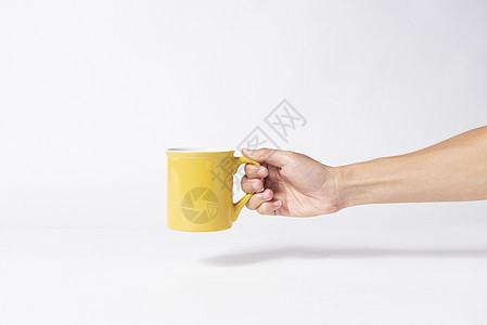 手握黄色陶瓷咖啡杯 创意设计品牌模型 孤立的白色背景   info whatsthis图片
