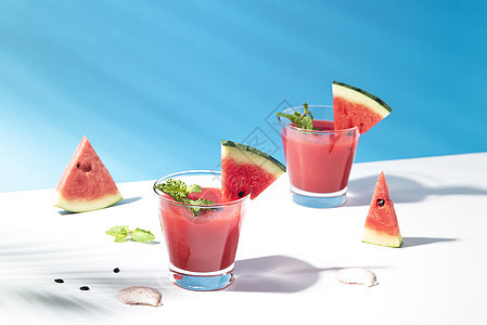 蓝底的鲜水甜瓜汁和西瓜片 夏季饮料图片