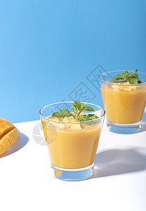 新鲜芒果冰淇淋和成熟的芒果切片 在彩色背景上 夏季饮料蓝色橙子液体水果异国情调食物热带饮食薄荷图片