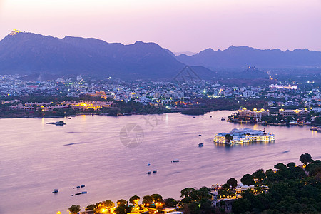乌代普尔市位于印度拉贾斯坦邦Pichola湖旅游历史反射奢华日落建筑学酒店全景旅行城市图片