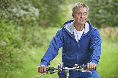 年长男子在乡村边享受周期性骑车运动服男人自行车退休骑术男性农村图片
