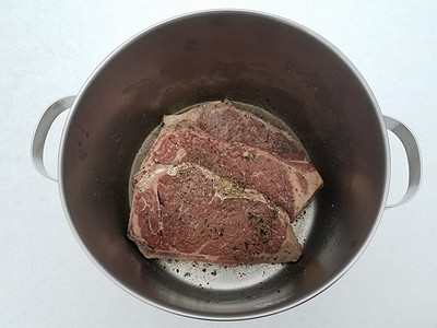 牛肉牛排 配有调料和雪上金属锅中的液体午餐冷冻牛扒白色食物图片