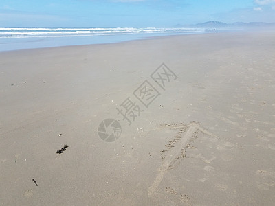 在俄勒冈州纽波特的沙滩上用箭撒沙海滩海洋波浪海岸图片