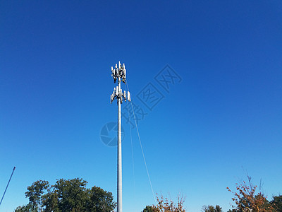 工人用绳子在高塔上修理维修绳索工业蓝色安全天空背景图片
