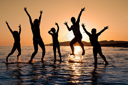 家庭跳跃的幻影儿子热带喜悦女性天空男生父母日落海洋乐趣图片