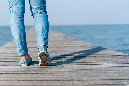 人类在通往自然的小型木桥上行走 用太阳耀斑漫步裙子小路男人女士团体蓝色男性踪迹日落女孩图片