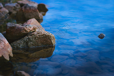 黄昏时湖岸上的自然石块岩石涟漪淡水空间石头环境支撑反射风景蓝色图片