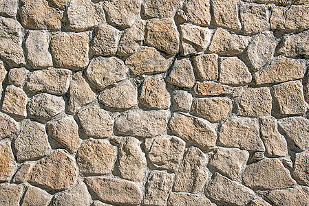 由天然石材制成的粗糙墙壁石匠古董工作岩石石墙石工水泥堡垒黏土砖墙背景图片