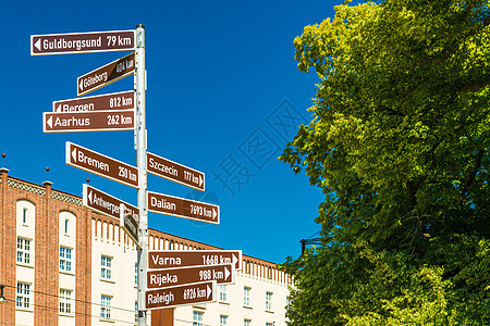 德国罗斯托克(Rostock)的街道标志 带有指路指示和通往世界不同城市的距离图片