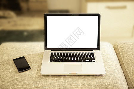带空白屏幕的开放式铝制笔记本电脑 用于复制空间和智能手机 放在沙发脚凳上 有选择地聚焦 有阴影的休息室背景技术自由职业者互联网公图片