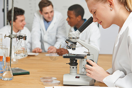 在科学课程中使用显微镜的女学生男生导师青少年大学图书中学女性高中写作班级图片