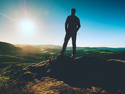 人类站在沙石岩的顶峰上 看着山谷向太阳飞去 美丽的时刻图片