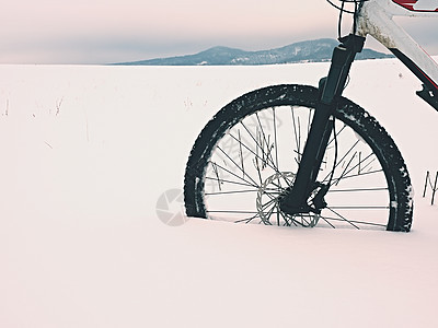 山地自行车的前轮在雪中停留 迷失了道路图片